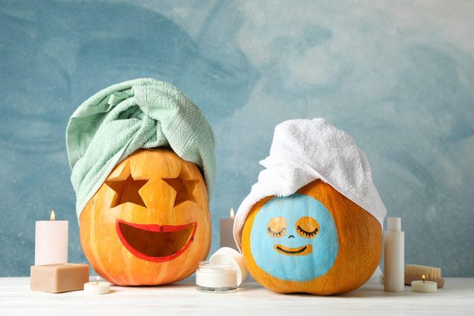 Funny pumpkins and skin care accessories on white background, copy space