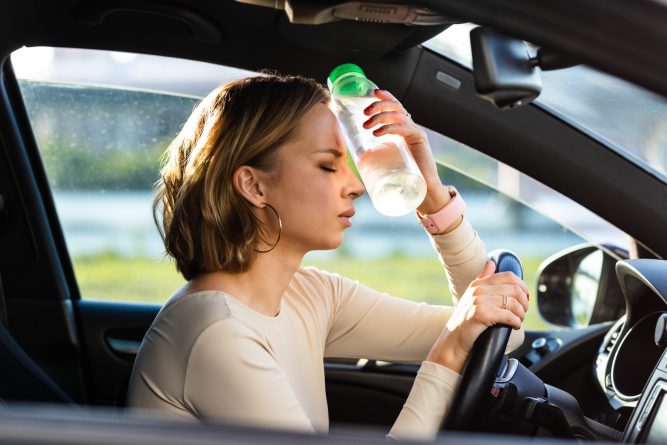 Exhausted woman driver feeling headache, sitting inside her car,