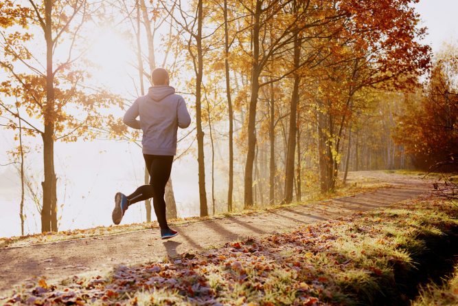 Man running in park at autumn morning. Healthy lifestyle concept